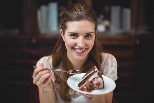 Portrait of smiling woman with desert in restaurant