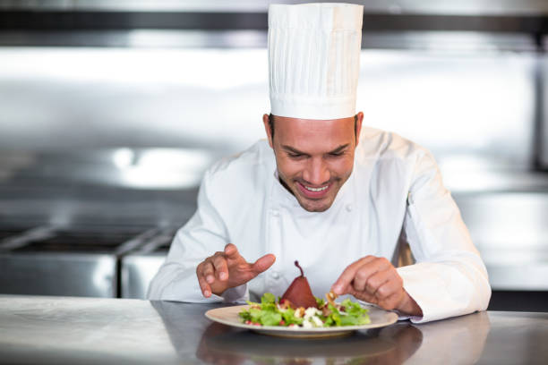 istock Happy chef garnishing food 667098538