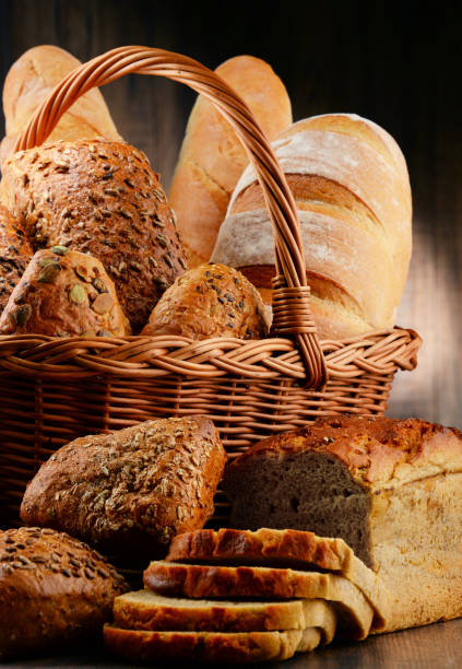 композиция с разнообразием хлебобулочных изделий на деревянном столе - bread bread basket basket whole wheat стоковые фото и изображения
