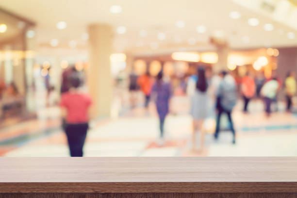 Empty wooden table for product display or montage and blurred shopping mall background.