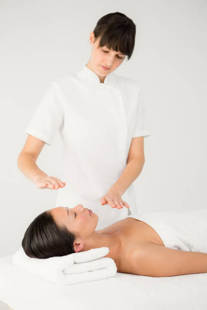 代替療法を受ける女性 - reiki alternative therapy massaging women ストックフォトと画像