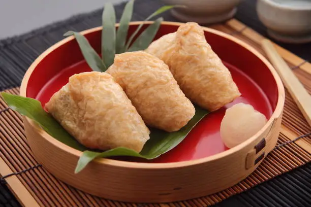 Inari Sushi, vinegared rice stuffed into pouches of deep-fried tofu; a favorite food of foxes, messengers of the rice god Inari