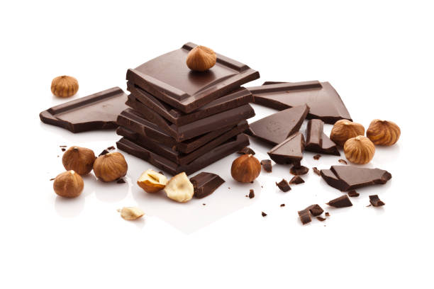 istock Chocolate pieces and hazelnuts isolated on white background 667114628