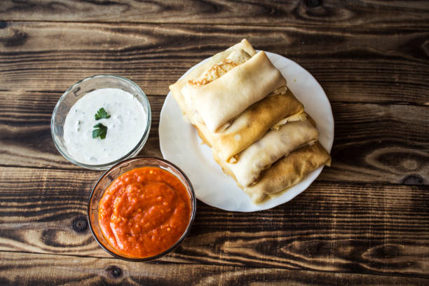 istock crepes with stuffing and white sauce and tomato 667116236