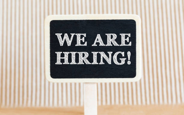 istock Handwritten text We are Hiring with white chalk on a blackboard on a paper background 667116328