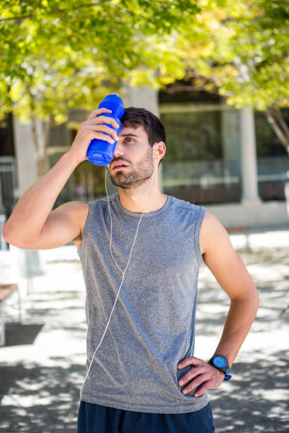 istock Exhausted runner putting a water bottle on head 667122328