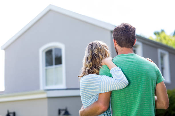 istock Couple standing against house 667135496