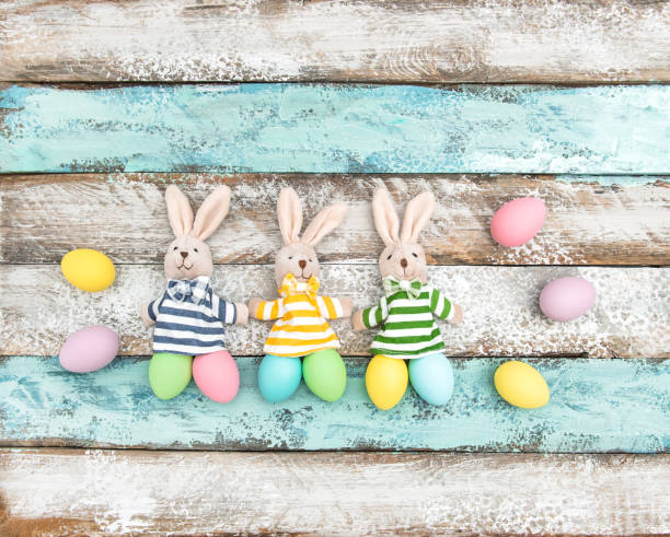 istock Easter decoration eggs funny bunnies wooden background 667135758