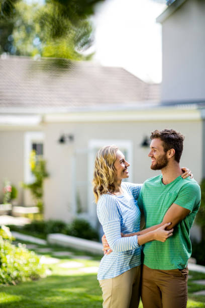 istock Couple hugging in yard against house 667138270