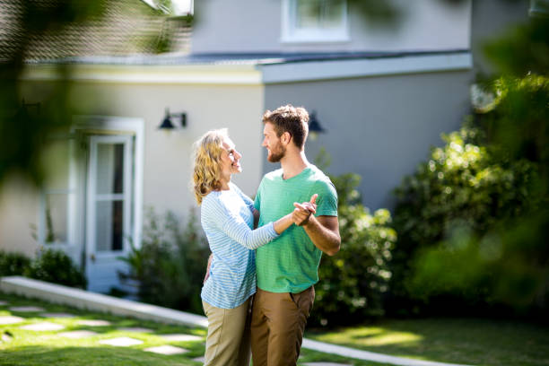 istock Couple dancing in yard against house 667138326