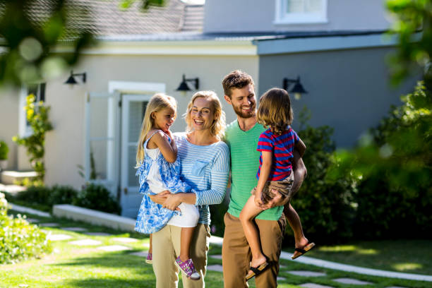 istock Smiling parents carrying children in yard 667138510