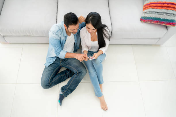 istock Couple at home social networking on a cell phone 667138542