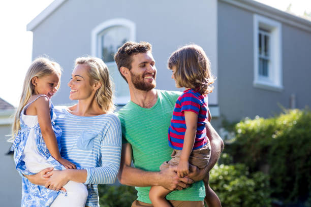istock Parents carrying children in yard 667138898