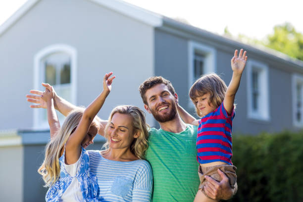 istock Happy parents carrying children with arms raised 667139264