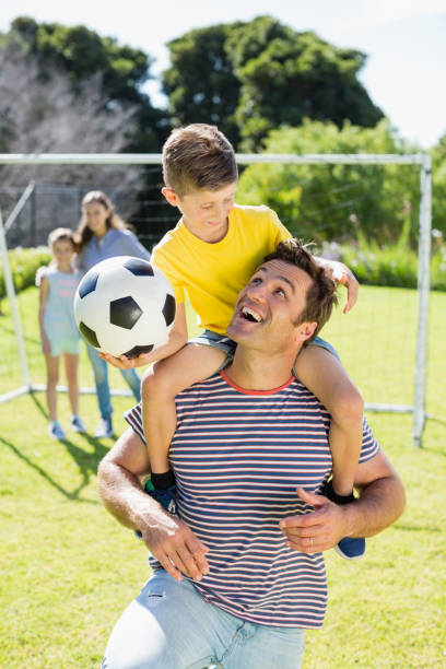 istock Smiling father carrying his son on shoulder 667139340