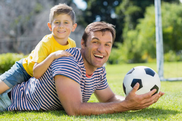 istock Father and son lying on grass in the park on a sunny day 667144034