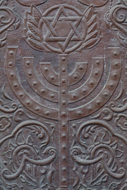 istock Ancient menorah and magen-david on an old gate 667144072