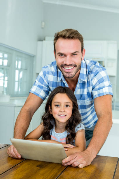 istock Father and daughter using digital tablet at home 667144406