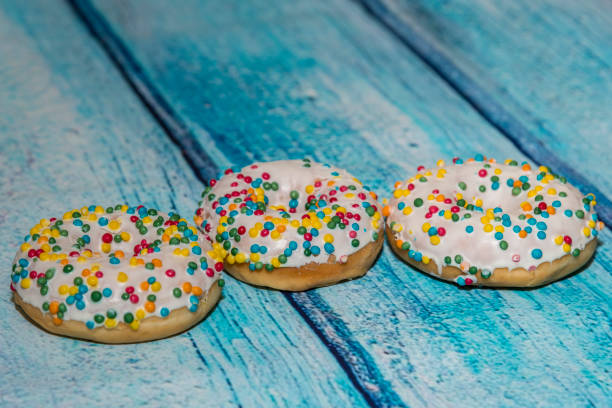 istock Sprinkles donuts on a blue wooden background 667147372