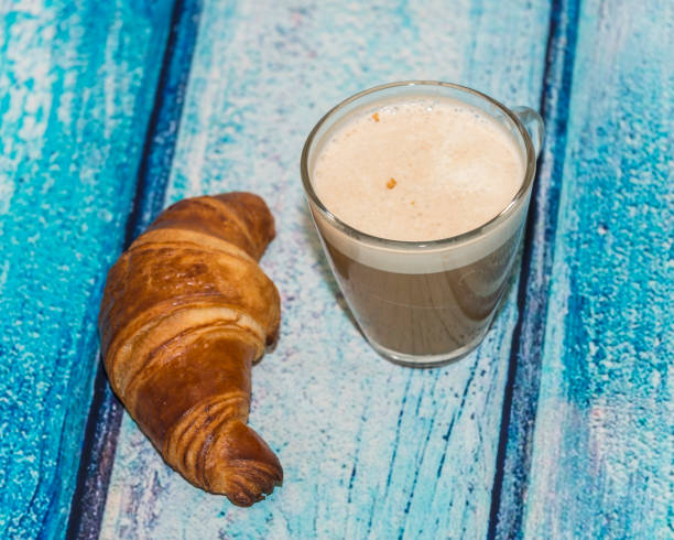 istock Coffee with croissant on a rustic wooden table 667147522