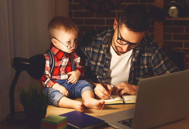 istock father and son baby work at home at computer in dark 667147954