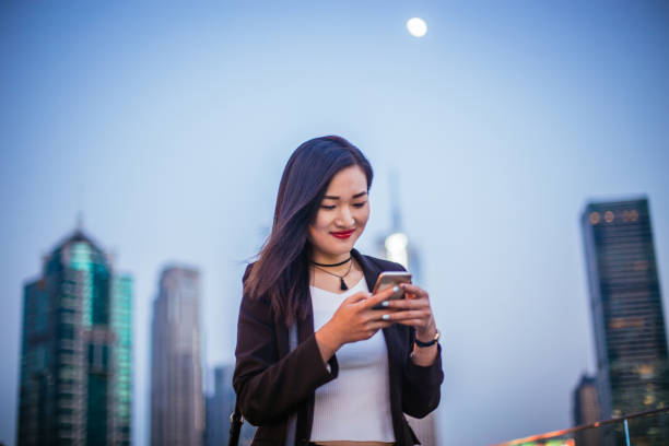 istock Chinese woman using phone 667148540