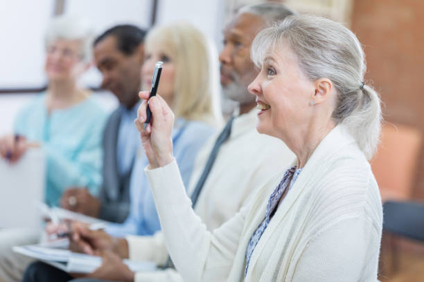 Senior woman asks question during seminar