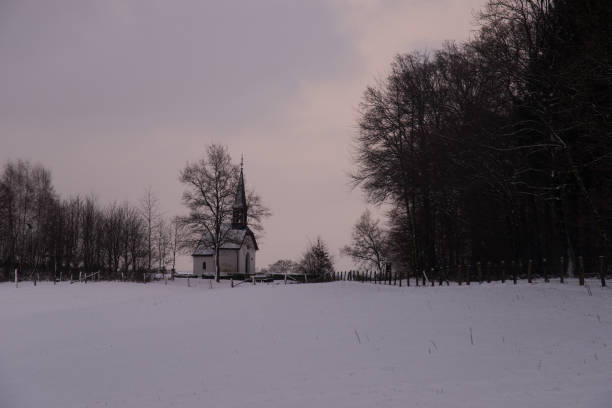 istock Small chapel in snowy winter landscape at dusk 667164798