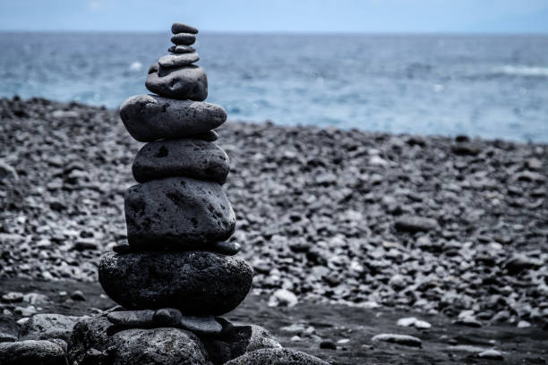 istock Stack of lava pebble stones on a black beach. La Palma, Spain 667166084
