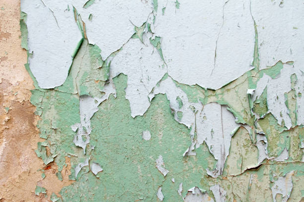 istock Vintage background texture of old brick masonry on ancient cement with cracks with traces of old paint. 667180174