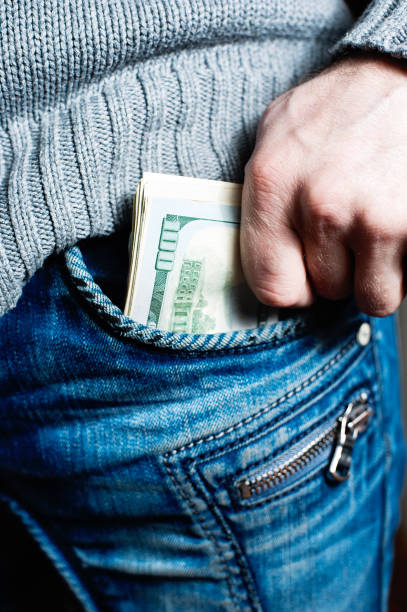 istock human hand is putting money in the pocket 667180300