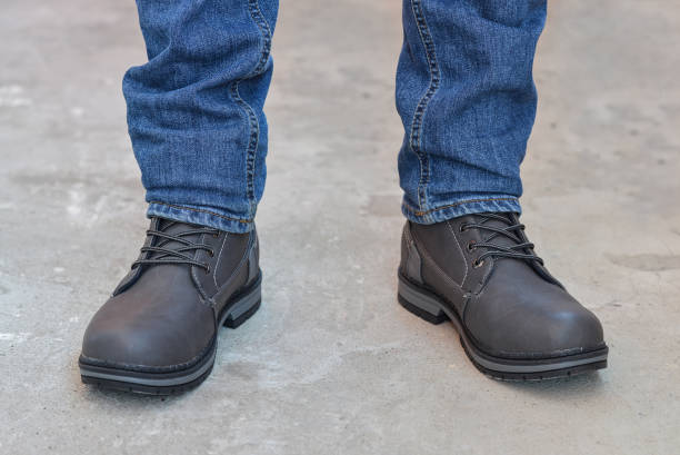 istock Young fashion man's legs in jeans and boots 667183444