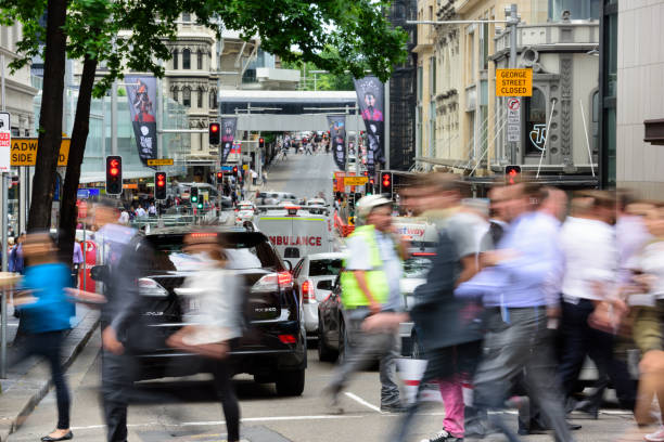 Sydney, Australia - November 12, 2015: People crowd crossing George Street in central Sydney. Mixed traffic and central Sydney in background.
