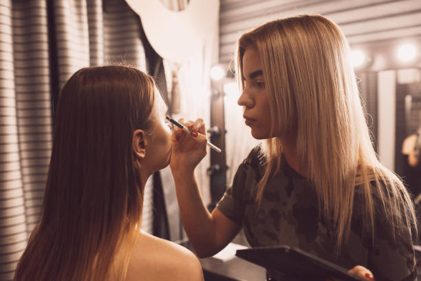 istock make up artist doing professional make up of young woman 667196122