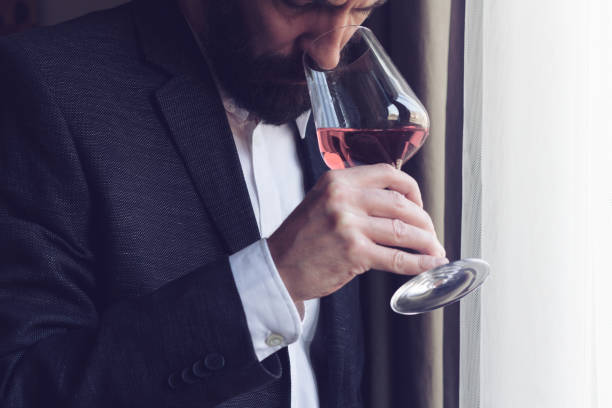 man tasting a glass of rose wine stock photo