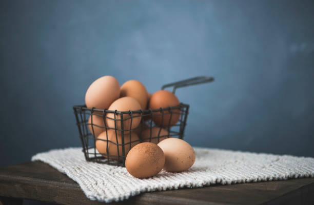 Fresh organic brown eggs in a basket in gray setting
