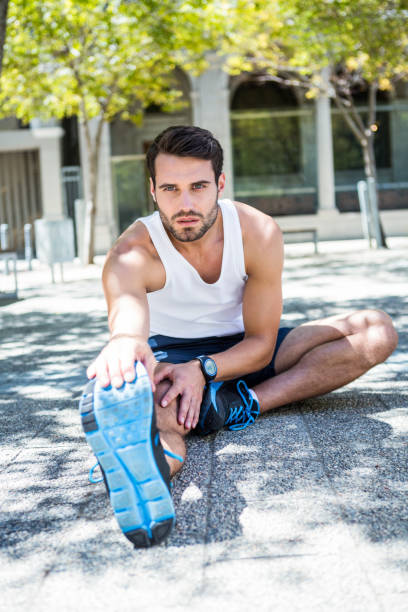 istock Handsome athlete sitting and stretching his leg 667202656
