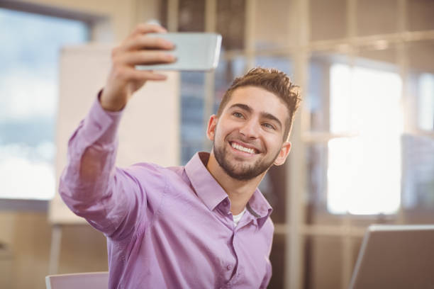istock Businessman taking selfie in creative office 667203992