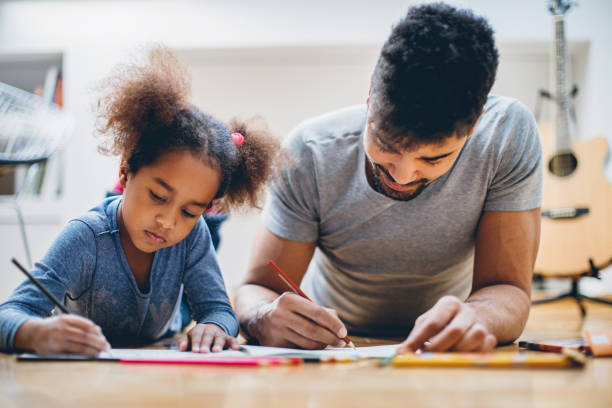 istock Father and daughter coloring together 667217274