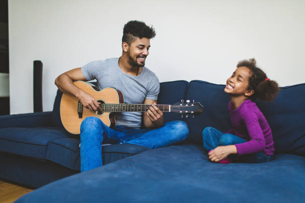 istock Loving father playing guitar for his kid 667217338