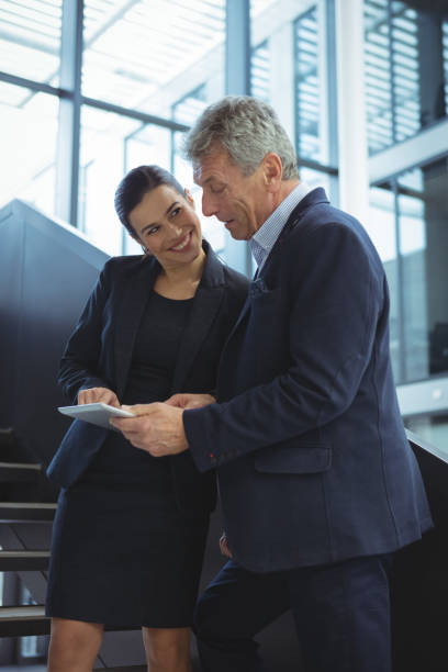 istock Business executives discussing over digital tablet on stairs 667217500
