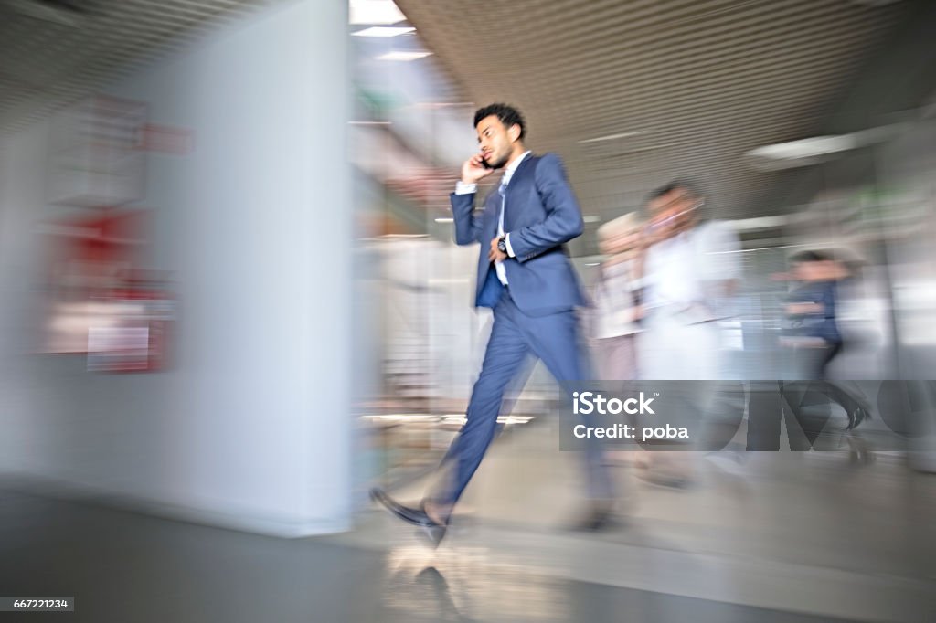 Mixed race businessman in busy workplace Blurred Motion Stock Photo