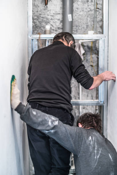 istock 70-years-old active senior man teaching the 30-years-old one. Construction workers - plumbers, working together for home renovation 667224582