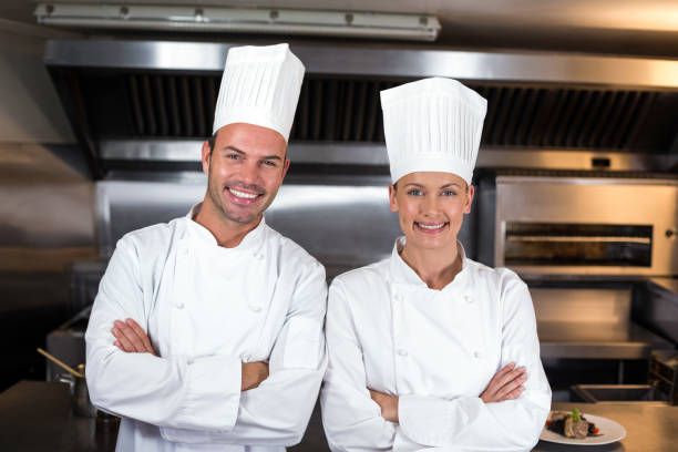 istock Portrait of happy chefs standing in kitchen 667227312
