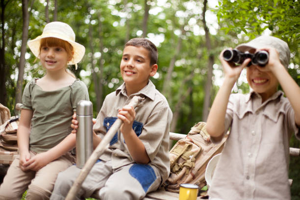 istock young boy  explores the nature with binoculars 667233966