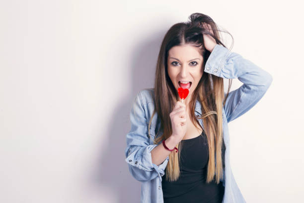 istock Young woman with a heart shaped lollipop. 667234488