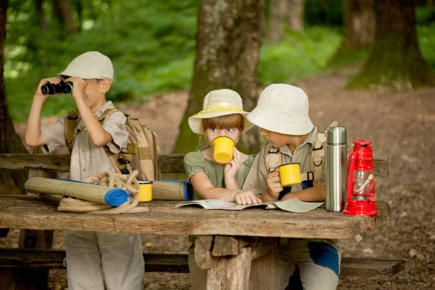 istock summer camps,scout children read map 667237280