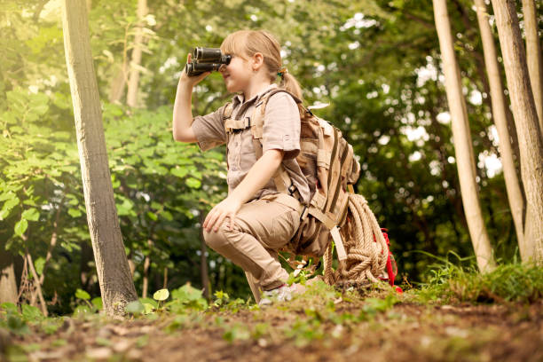 istock young girl scout, explores  nature with binoculars on camping trip 667244956