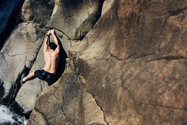 istock rock climber on cliff, deep water soloing 667245414