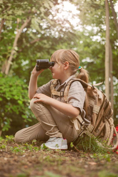 istock young girl scout, explores  nature with binoculars on camping trip 667247772